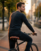 Man commuting on a city bike seated on the brown ergonomic saddle at sunset