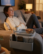 Woman on a sofa with the arm organizer holding coffee, snacks and remotes