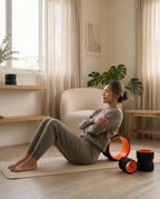 Woman stretching her back over the orange roller in a bright living room