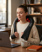 Woman at a desk using the heated neck massager over her shoulders