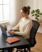 Woman typing at a desk with the lumbar pillow supporting her office chair