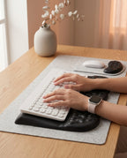 Hands typing on a keyboard with wrists resting on the ergonomic support pad