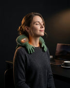 Woman at her desk wearing the green neck and shoulder massager