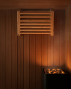 Wood sauna ventilation grille mounted on the wall above a sauna heater