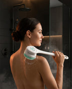 Woman in steamy shower scrubbing her back with the long-handle body cleansing brush