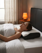 Woman sleeping on her back on the cervical pillow in a warm-lit bedroom