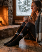 Woman in heated socks relaxing by a fireplace in a winter cabin
