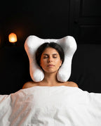 Woman back-sleeping with head nested in the white wing-shaped support pillow