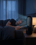Man asleep at night as the black bladeless tower fan blows cool air bedside