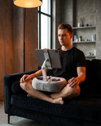 Man working from home on a couch, tablet pillow stand propped on his lap