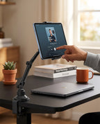 Hand tapping a tablet held by the clamp-mounted holder on a home office desk