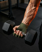 Hand holding a hex dumbbell while wearing a green grip pad, forearm flexed