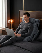 Man working on laptop in bed leaning on grey wedge support cushion