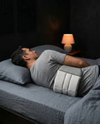 Man lying on his back in bed with the lumbar cushion supporting his spine