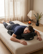 Man relaxing face-down with chest and face resting on the black support pillow