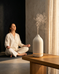 White ceramic essential oil diffuser misting in a calm meditation corner