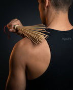 Man tapping his shoulder with the bamboo massage roller for recovery