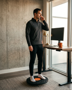 Man on a phone call standing on the balance board at his standing desk