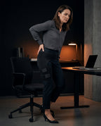 Office worker standing by her desk wearing the hip support wrap