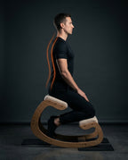 Side profile of a man on the kneeling chair with spine alignment highlighted