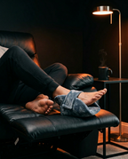Feet wrapped in the heel cushion while reclining in a leather chair at night