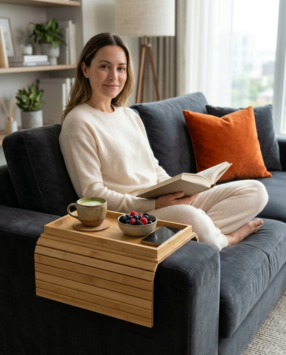 Woman reading on a sofa with the slatted bamboo tray over the armrest