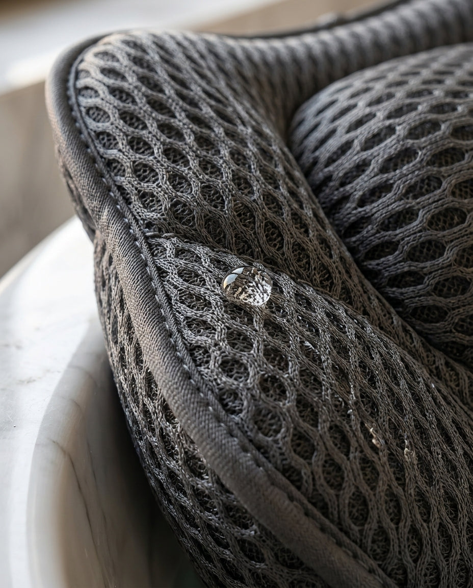 Macro of the 3D air-mesh texture with a water droplet on the bath pillow