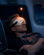 Man resting in an airplane seat wearing the silk sleep eye mask