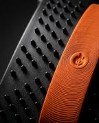 Macro of the black acupressure nubs and ribbed orange spine pad with flame logo