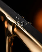Macro of the black silicone blade and water droplets on the brass squeegee head