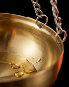 Macro of polished brass sauna bowl finish with golden oil droplets