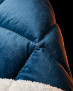 Macro of the navy box-quilted stitching meeting the cream sherpa edge