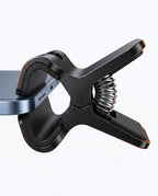 Macro of the spring-loaded clamp head gripping a phone edge with padded jaws