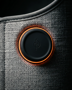 Macro of the round control puck with orange ring on the leg warmer's grey fabric