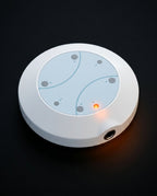 Top-down macro of the round white foot spa controller with LED indicator