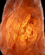 Macro of the rough amber crystal texture of the glowing Himalayan salt lamp