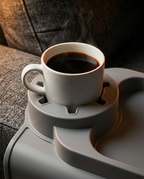 Close-up of the cup holder cutout holding a steaming coffee cup