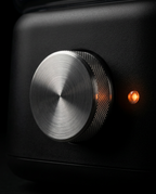 Macro of the brushed metal control dial and amber LED on the towel warmer