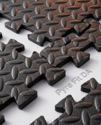 Macro of the black diamond-plate texture and interlocking teeth of the foam mat