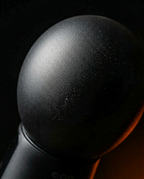 Macro close-up of the rounded black dome head of the massage gun