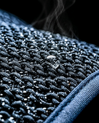 Macro of textured evaporative cooling fabric with water droplets and rising vapor