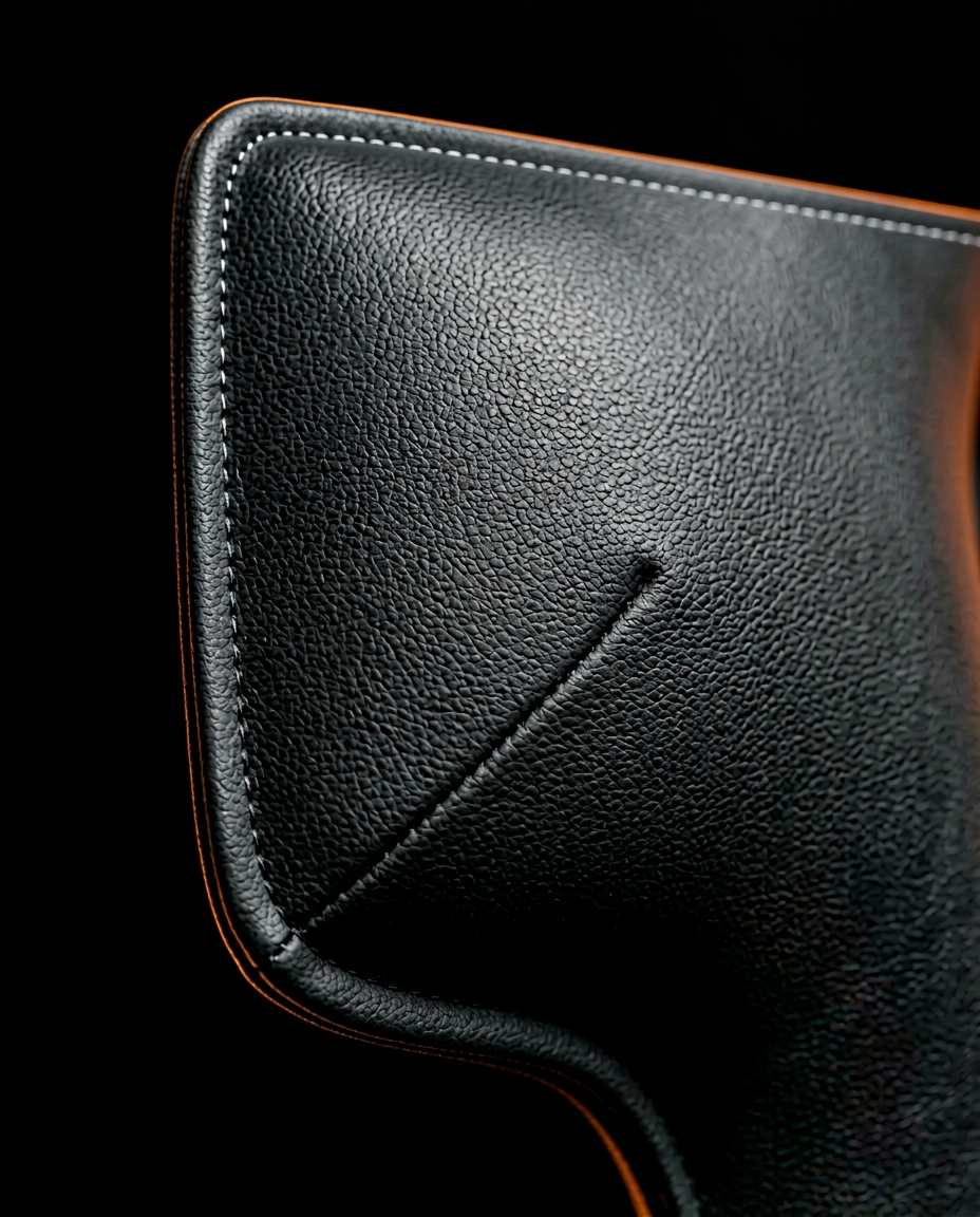 Macro of the black faux leather texture and stitched corner of a wall panel