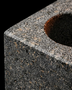 Macro of the speckled natural granite texture on the cube oil holder