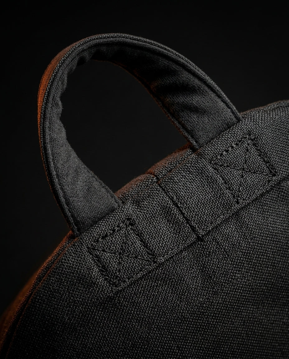 Macro top-down of the reinforced stitched carry handle on the fabric pillow