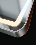 Macro of the LED vanity mirror's glowing halo border and brushed metal frame corner