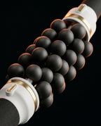 Macro of the rotating black massage balls and gold-trimmed rollers