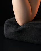 Macro of an elbow sinking into the plush black memory foam armrest