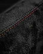Macro of the soft black microfiber weave with orange stitching on the cushion