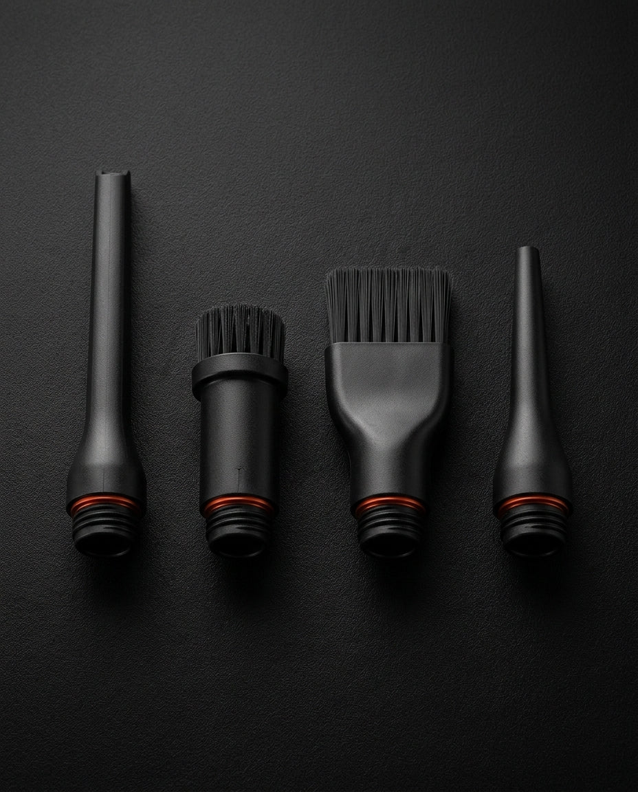 Macro of four black nozzle and brush attachments for the cleaning tool