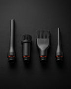 Macro of four black nozzle and brush attachments for the cleaning tool